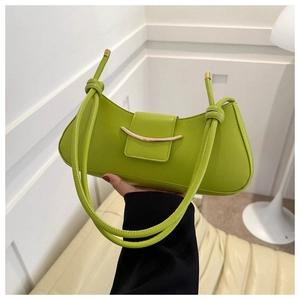 Detail of green leather shoulder bag with gold metal buckle and knotted strap accents