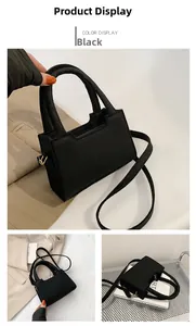 Detailed close-up of a black felt crossbody bag with gold zippers and fixed top handles