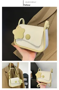 Detail of yellow and beige patchwork crossbody bag with star pendant and magnetic buckle