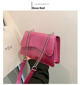 Detail of rose red patent leather bag with wave flap and silver chain strap