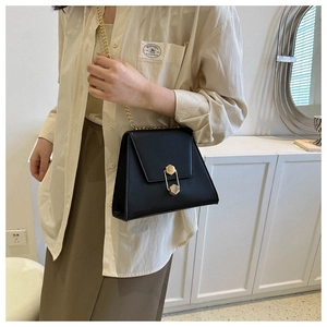 Détail d'un sac chaîne en cuir PU noir avec un fermoir hexagonal doré en situation réelle