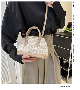 Détail d'un sac coquillage tissé avec garniture en cuir kaki et bandoulière amovible