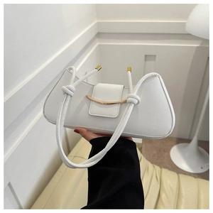 Detail of white leather shoulder bag with gold crescent buckle and knotted strap accents