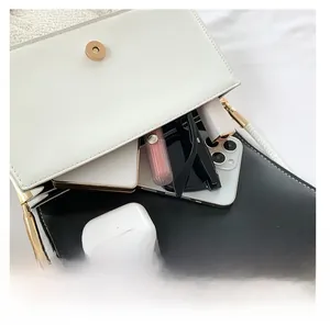Detail view of the interior capacity of a black and white flap bag with daily essentials