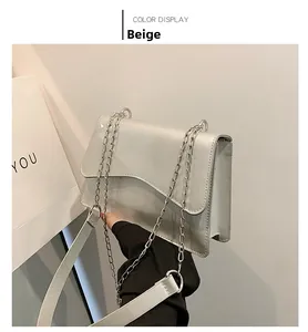 Side view of beige chain shoulder bag with wavy flap design and glossy finish