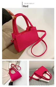 Detail of vibrant hot pink felt handbag showing trapezoidal shape and matching shoulder strap