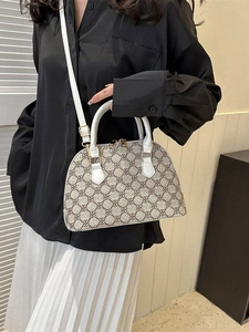 Retro monogram shell bag with white trim and gold hardware, shown with fashion outfit