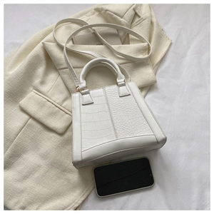 Detailed top view of white crocodile pattern handbag with shoulder strap and phone reference