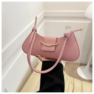 Detailed view of pale pink minimalist handbag featuring a golden crescent metal lock buckle
