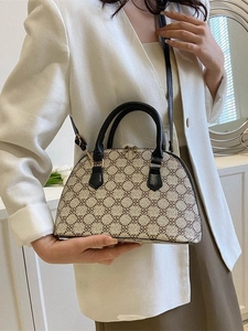 Elegant beige shell-shaped handbag with dark brown clover pattern and black leather handles