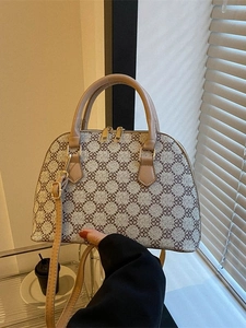 Retro shell tote bag with brown clover pattern and adjustable shoulder strap shown in lifestyle view