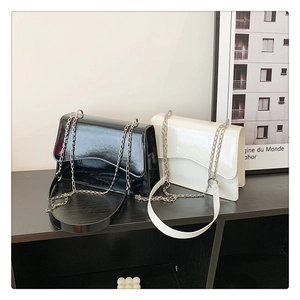 Minimalist glossy patent leather crossbody bags with silver chain straps in black and white