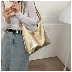 Close-up of metallic gold tote bag showing sleek texture and large capacity on model