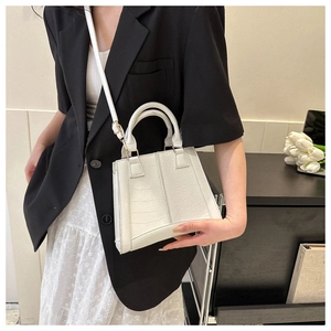 White crocodile embossed leather handbag shown on model for size and style reference