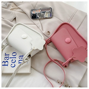 Detail view of the stylish PU leather square bag with flap closure and floral charm