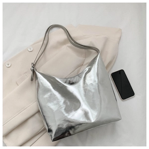Detailed top view of a large silver metallic hobo tote bag on white fabric background