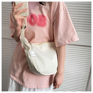 Detail of a white crescent crossbody bag with a cute cloud charm and wave texture phone case