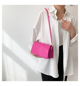 Chic magenta leather shoulder bag worn by model against a neutral minimalist wall