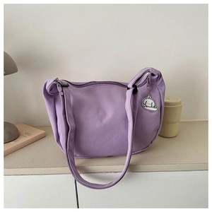 Detail of light purple corduroy hobo bag with a cute white dog charm and adjustable strap