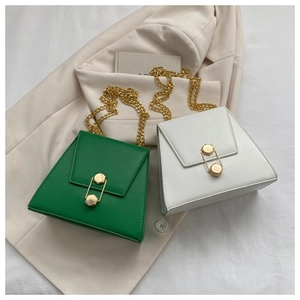 Détail de sacs enveloppe verts et blancs avec fermoir trombone doré et bandoulière chaîne