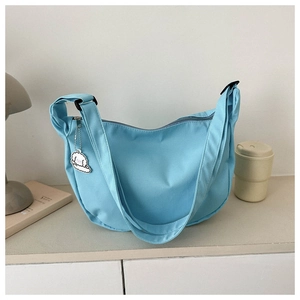 Stylish light blue PU leather underarm bag featuring a cute cartoon dog charm accessory