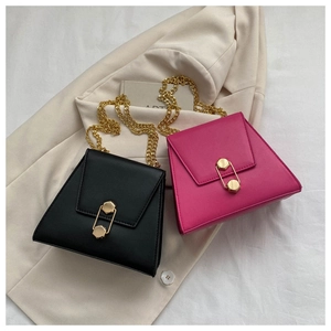 Détail de sacs à chaîne élégants en noir et magenta avec un fermoir trombone doré unique