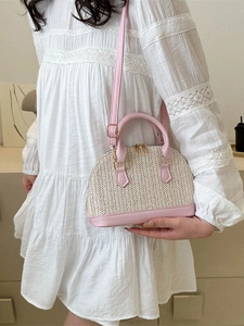 Sac coquillage tissé en paille beige avec finitions en cuir rose et bandoulière