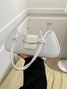 Minimalist white leather baguette bag with golden metal buckle and knot strap detail