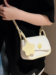 Minimalist white leather crossbody bag with yellow contrast trim and flower charm accessory