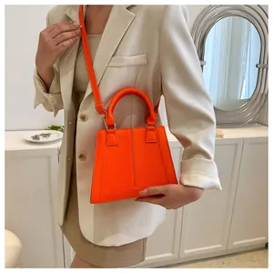 Detail of orange crossbody bag with textured crocodile pattern and matte stitching