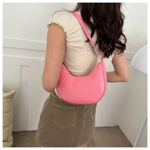 Pink crescent underarm bag featuring premium crocodile pattern and gold hardware detail