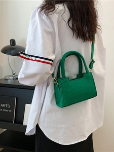 Elegant emerald green felt crossbody handbag with top handle and gold-tone hardware