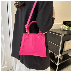 Crocodile pattern fuchsia small square bag with top handle and gold hardware on model