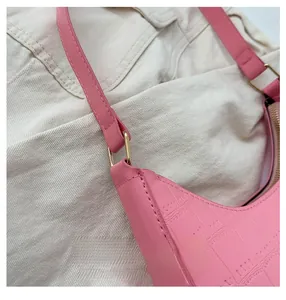 Close-up of pink crocodile texture leather with golden ring buckle on shoulder bag