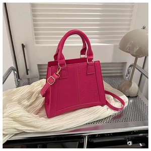 Detailed macro view of hot pink bag showing smooth leather and embossed crocodile texture