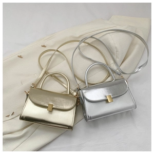 Detail of metallic gold and silver crossbody bags with metal buckle and top handles