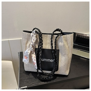 Detailansicht der gewebten Strohtasche mit schwarzer Summer-Tasche und dekorativem Seidenschal