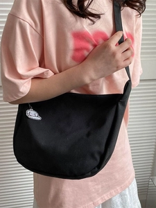 Minimalist black half-moon crossbody bag with cute cloud charm and adjustable strap