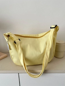 Minimalist yellow canvas crossbody bag with adjustable strap and zipper closure
