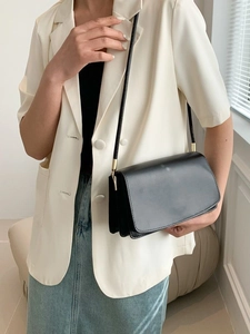 Minimalist black leather crossbody bag with gold hardware and flap rectangular silhouette