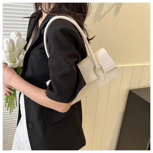 Close-up of a white leather rectangular flap bag styled with a black blazer and tulip
