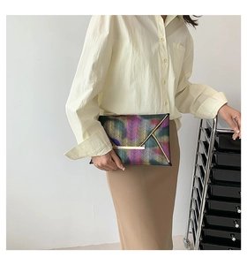 Detail der bunten V-Muster-Umschlagtasche mit eleganten goldenen Metallakzenten am Rand