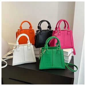 Detail of multi-color crocodile pattern tote bags in orange black pink white and green