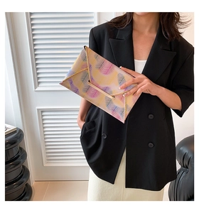Detail der bunten Umschlag-Clutch mit Zickzack-Muster und goldenen Metallkanten
