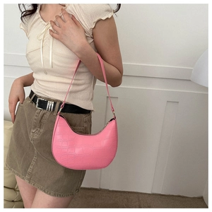 Close-up of pink crescent underarm bag featuring premium crocodile embossed texture
