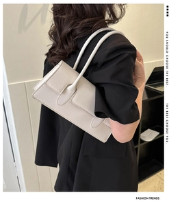 Minimalist beige underarm bag styled with a black blazer for a professional fashion look