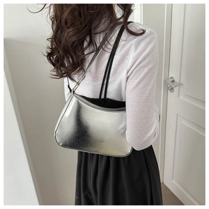 Close-up of metallic silver hobo bag with reflective mirror finish and fashion logo