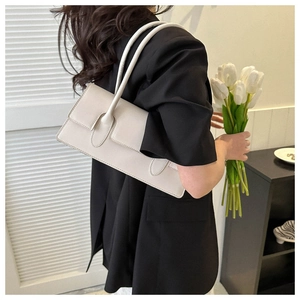 Minimalist white leather baguette bag with ring buckle strap worn with black blazer