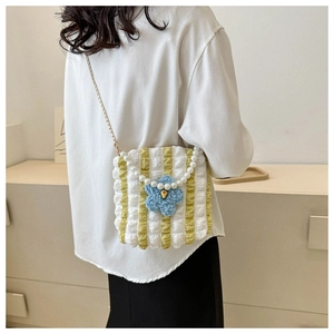 Detail of yellow striped bubble tote bag with pearl handle and plush blue flower