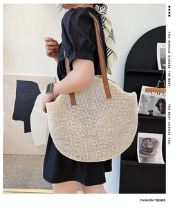 Close-up of the textured beige woven fabric and brown leather shoulder strap detail